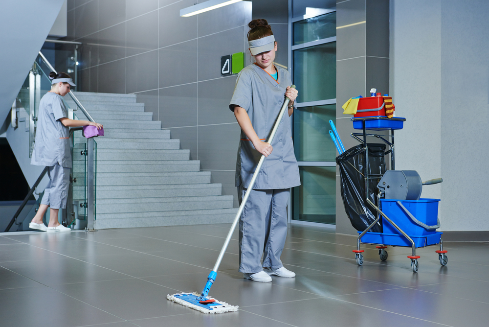 worker cleaning floor with machine